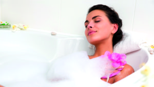 Eine Dame badet entspannt in einem Schaumbad.